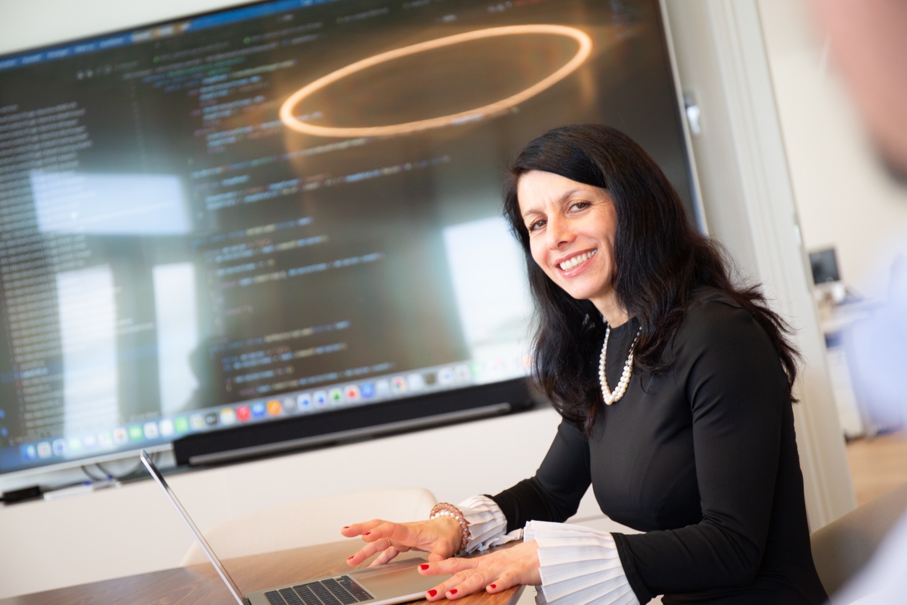 A SYN IT colleague at work in front of a large screen in the Vienna office