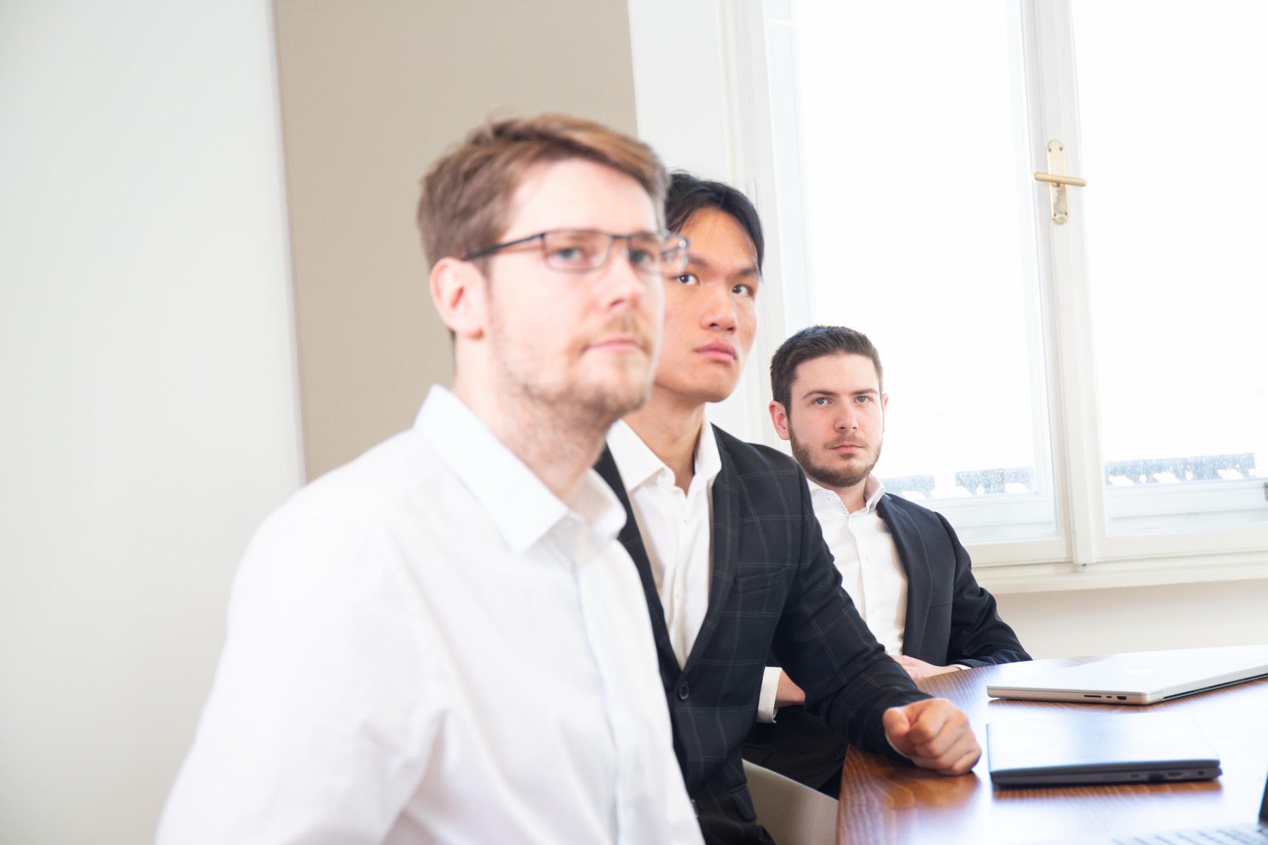 Three SYN IT colleagues reviewing work together in the Vienna office