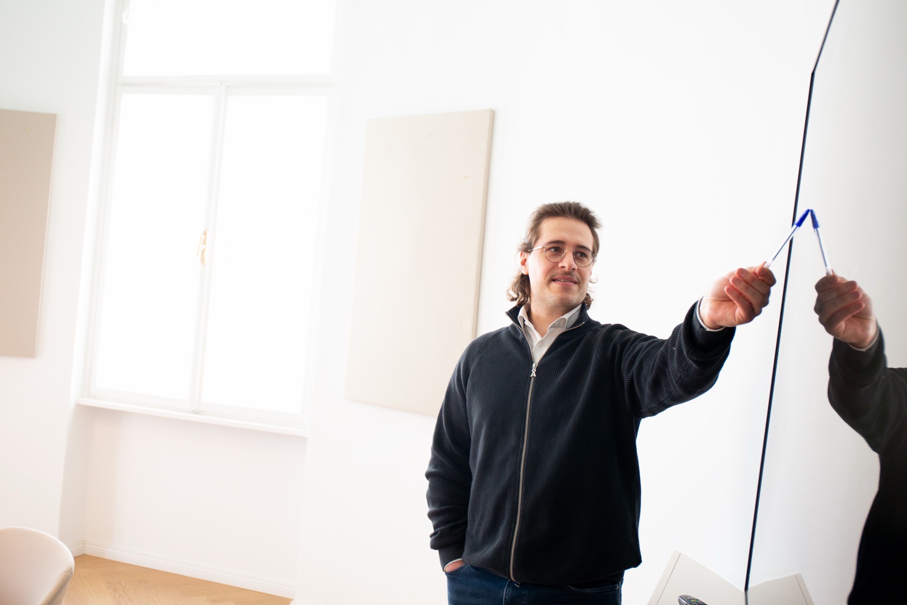 A SYN IT colleague sketching at a whiteboard during a workshop in the Vienna office