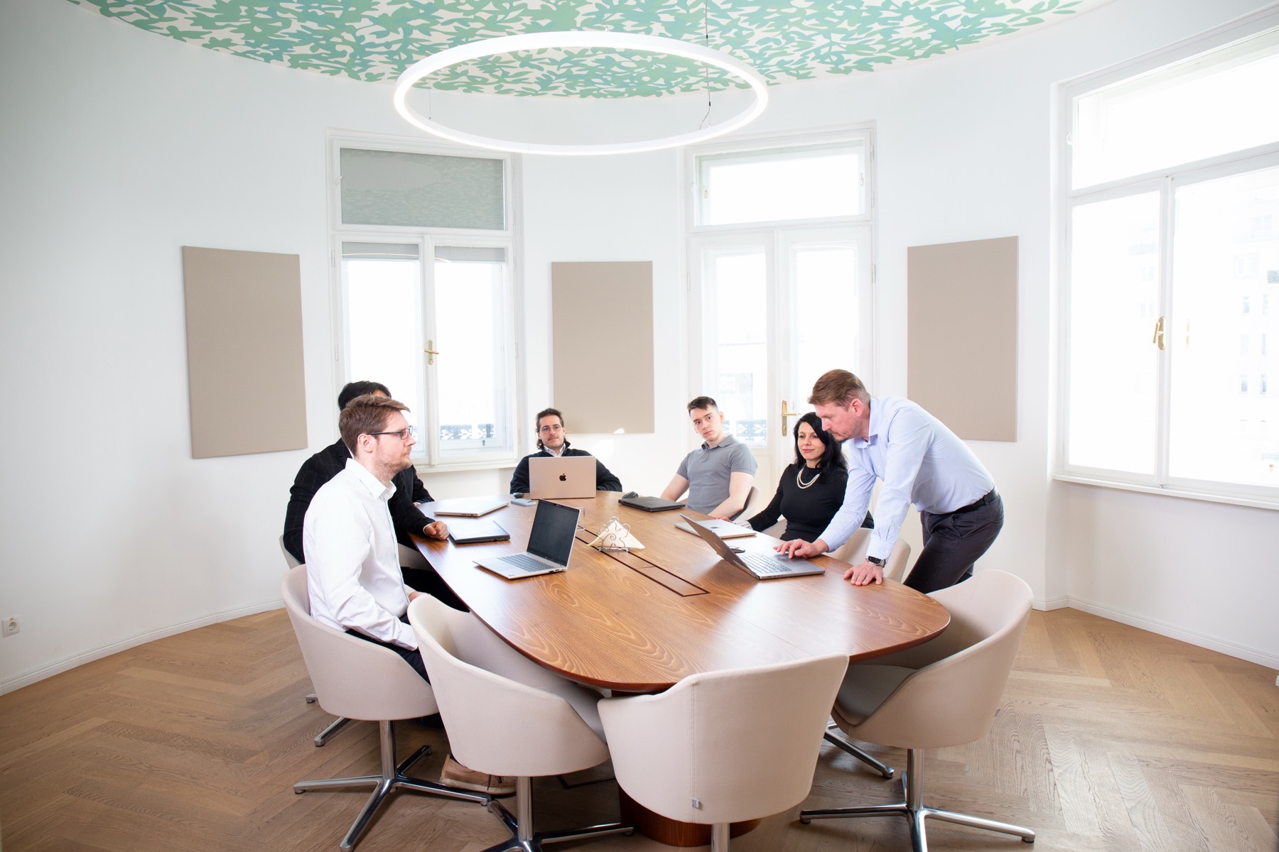 SYN IT colleagues working through a problem together around a meeting table in the Vienna office.